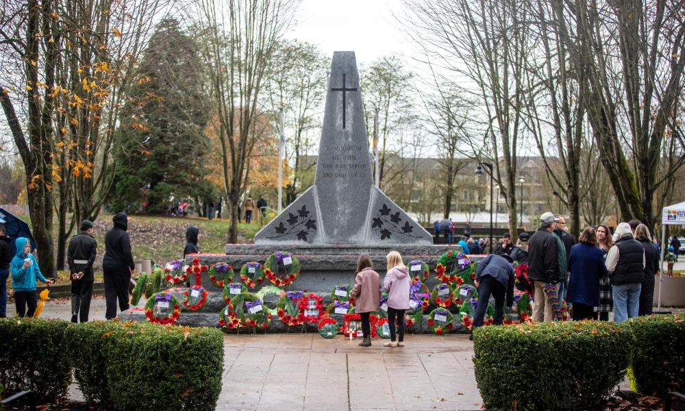 Image of the Pitt Meadows cenotaph with two children standing in front of it