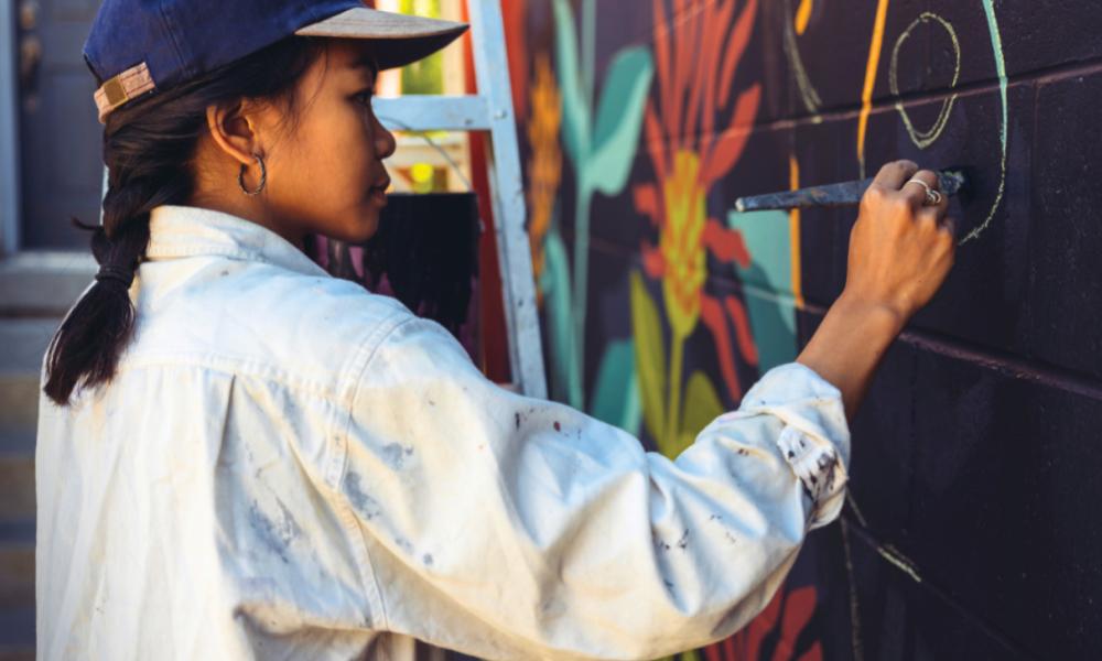 person painting a wall mural