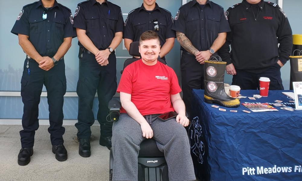 firefighters and person in wheelchair in front of storefront