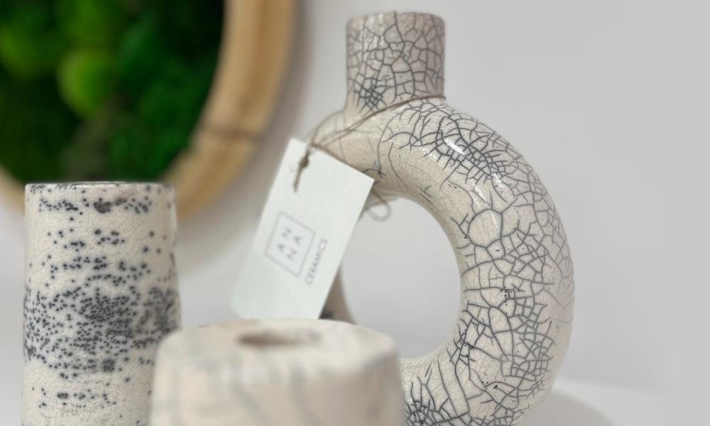 a handmade circular vase with a hole in the middle and two candle holders