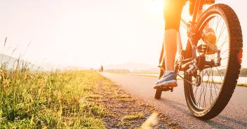 person biking on a sunny trail